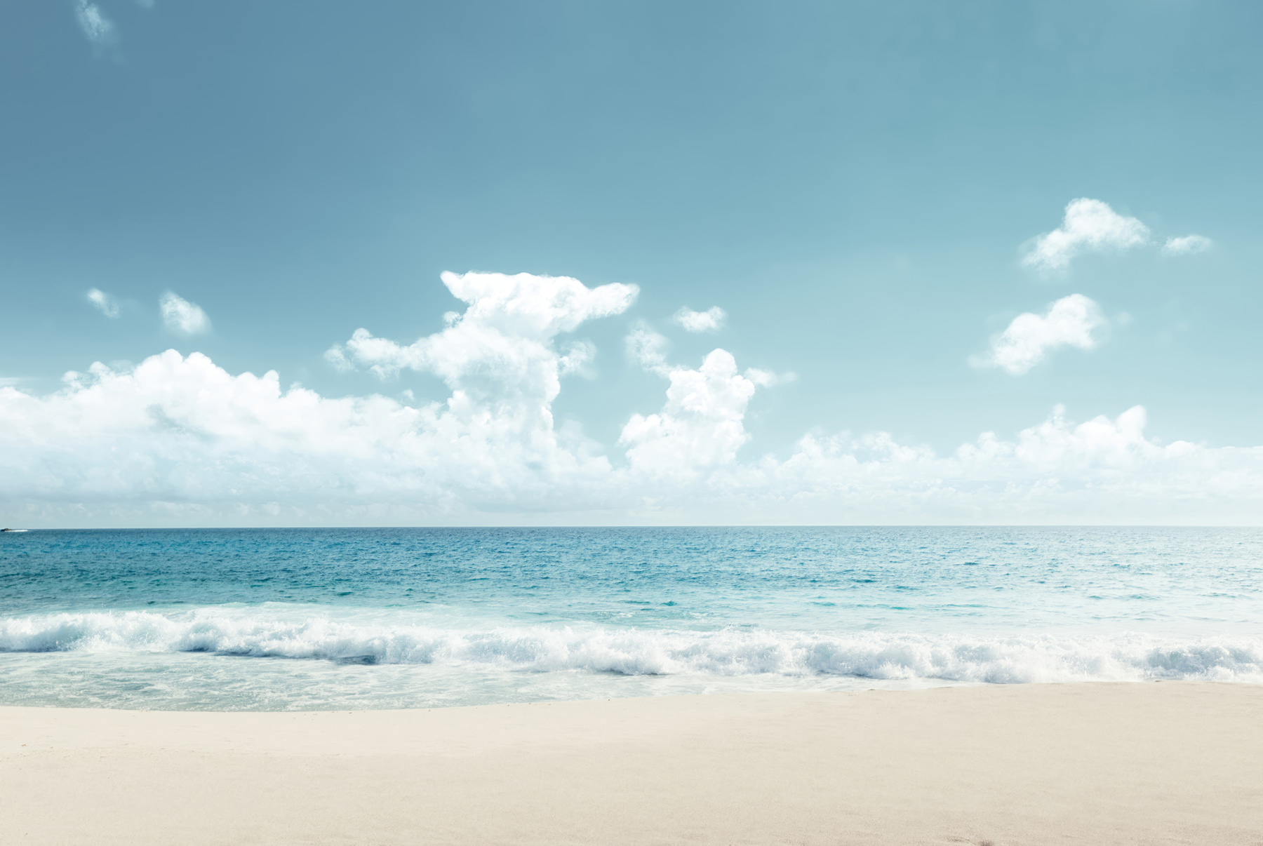 A beach with waves crashing on the sand A beach with waves crashing on the sand
