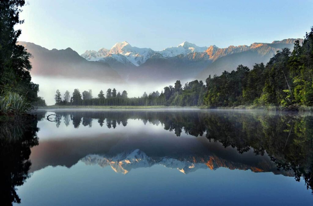 Lac cu copaci și munți în fundal Lac cu copaci și munți în fundal