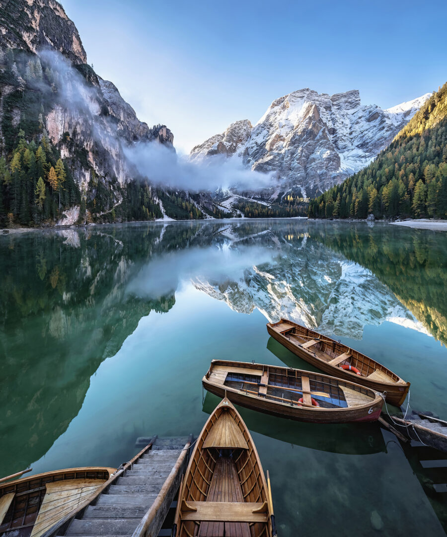 Bărci pe un lac cu munți în fundal