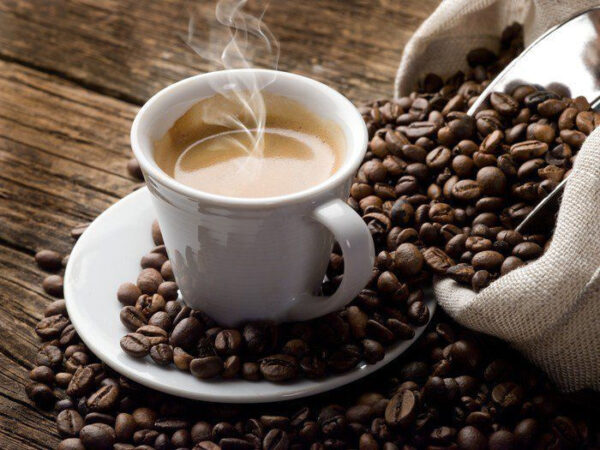 Ceașcă de cafea pe o farfurie cu boabe de cafea Ceașcă de cafea pe o farfurie cu boabe de cafea