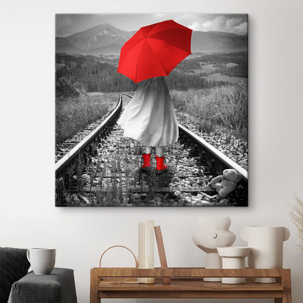 O persoană cu o umbrelă roșie pe o linie de tren O persoană cu o umbrelă roșie pe o linie de tren