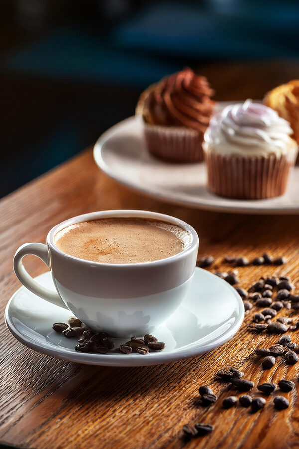 Ceașcă de cafea și cupcakes pe o masă Ceașcă de cafea și cupcakes pe o masă