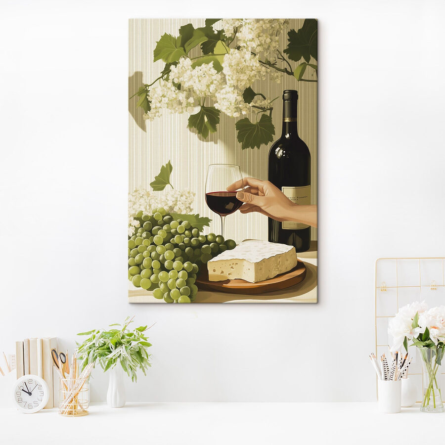 O mână care ține un pahar de vin lângă o sticlă de vin
