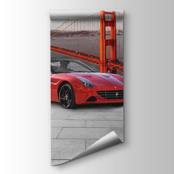 Red sports car on a road with a bridge in the background