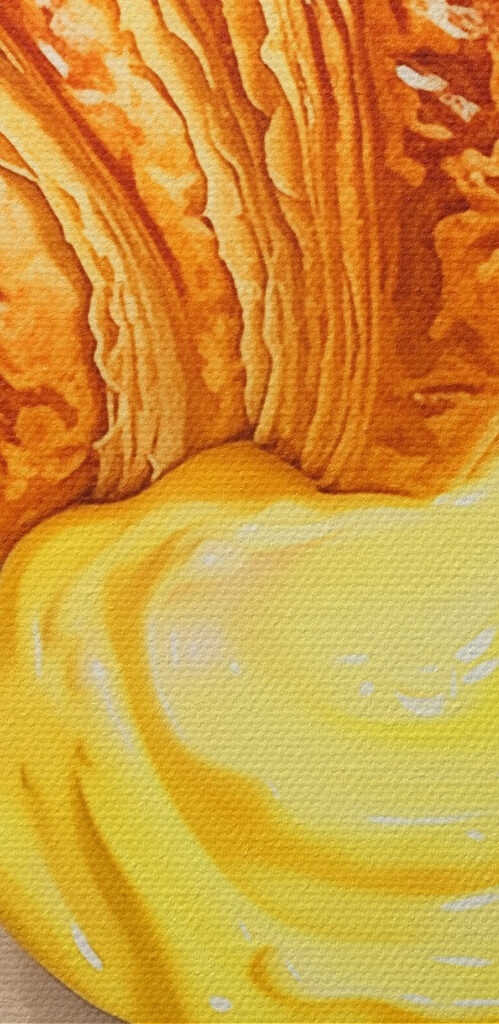 Croissant and a yellow liquid on a plate